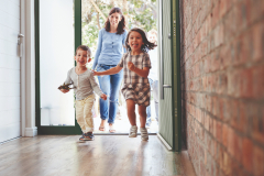 Excited Children Arriving Home With Parents